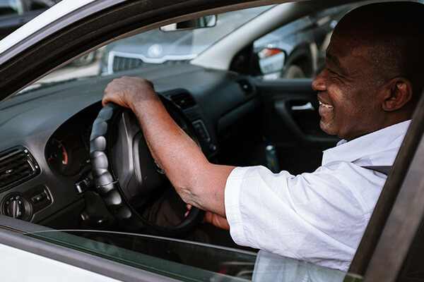 smiling man driving a car